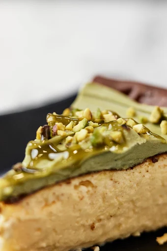 Porción de cheesecake cubierta de crema de pistacho