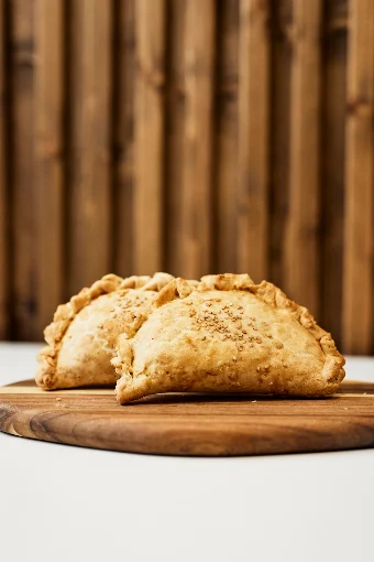 Empanadas argentinas recién horneadas sobre tabla de madera