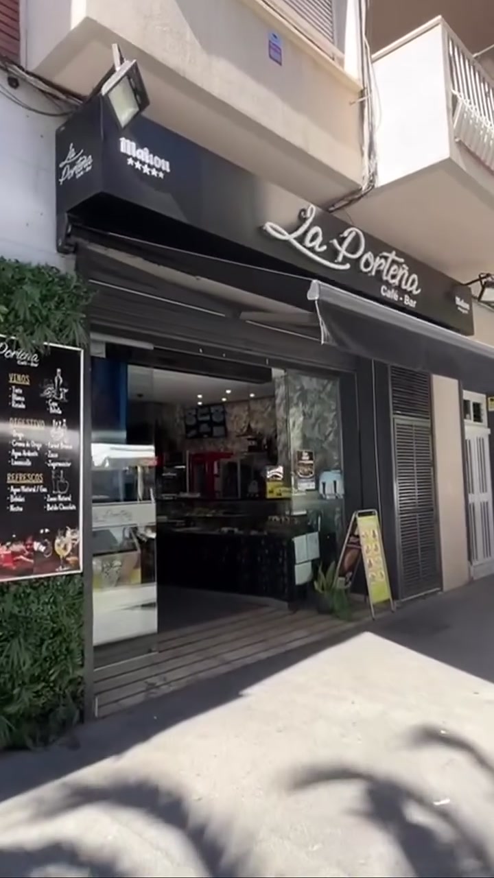 Fachada de La Porteña Café-Bar, con la pizarra de la carta y el jardín vertical en la entrada