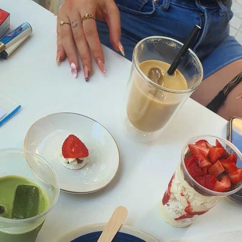 Mesa del local con café helado, matcha y una mini pavlova